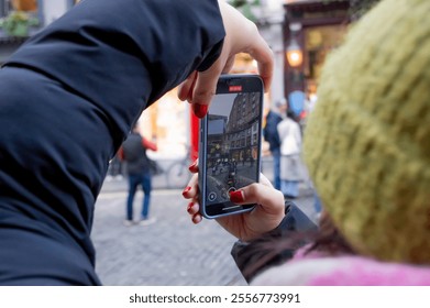 Person capturing a bustling city street scene on smartphone camera in daylight - Powered by Shutterstock