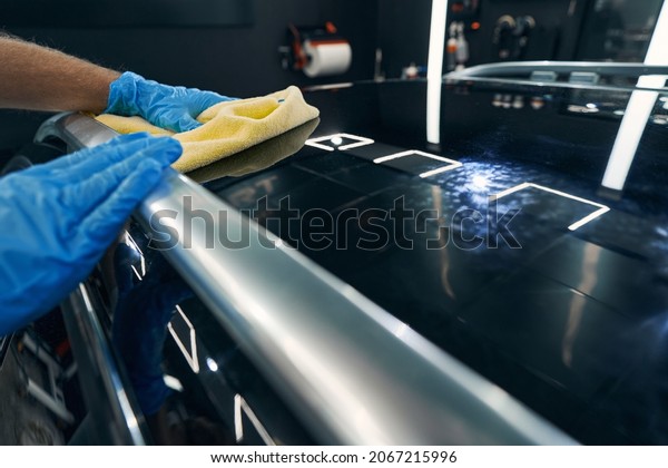 Person\
in car service washing automobile roof with\
cloth