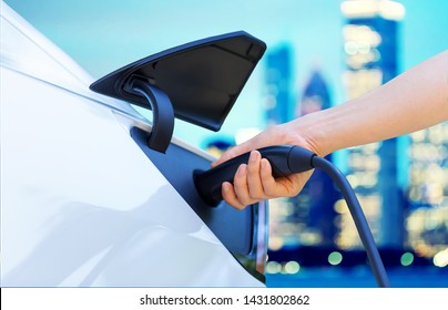 Person Charging An Electric Vehicle In The City