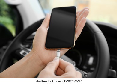 Person Charging Phone With USB Cable In Car