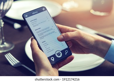 Person Choosing Food For Dinner From Mobile Phone App Menu At Restaurant