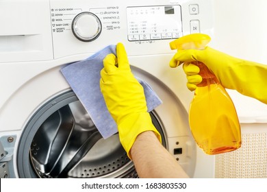 Person In Chrome Gloves Cleaning Washing Machine With Cleanser And Rag