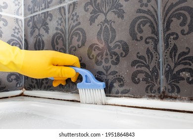 Person Cleaning Mould And Mildew From A Shower Cubicle With A Scrubbing Brush. 