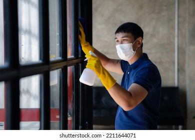 Person Cleaning The Room, Cleaning Staff Is Using Cloth And Spraying Disinfectant To Wipe The Glass In The Company Office Room. Cleaning Staff. Concept Of Cleanliness In The Organization.