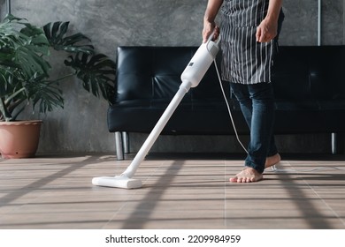 Person Cleaning Room, Cleaning Worker Is Using A Vacuum Cleaner To Clean The Living Room Floor In The Company Office. Cleaning Staff. Maintaining Cleanliness In The Organization.