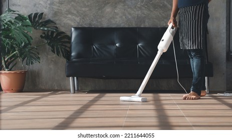 Person Cleaning Room, Cleaning Worker Is Using A Vacuum Cleaner To Clean The Living Room Floor In The Company Office. Cleaning Staff. Maintaining Cleanliness In The Organization.