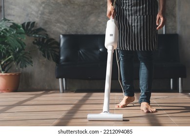 Person Cleaning Room, Cleaning Worker Is Using A Vacuum Cleaner To Clean The Living Room Floor In The Company Office. Cleaning Staff. Maintaining Cleanliness In The Organization.