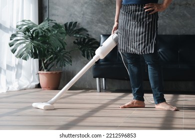 Person Cleaning Room, Cleaning Worker Is Using A Vacuum Cleaner To Clean The Living Room Floor In The Company Office. Cleaning Staff. Maintaining Cleanliness In The Organization.