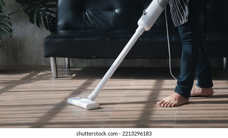 Person Cleaning Room, Cleaning Worker Is Using A Vacuum Cleaner To Clean The Living Room Floor In The Company Office. Cleaning Staff. Maintaining Cleanliness In The Organization.