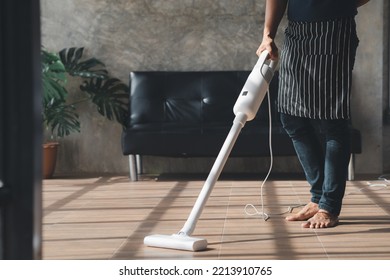 Person Cleaning Room, Cleaning Worker Is Using A Vacuum Cleaner To Clean The Living Room Floor In The Company Office. Cleaning Staff. Maintaining Cleanliness In The Organization.