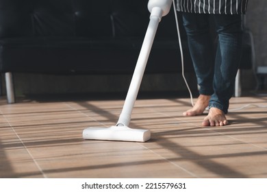 Person Cleaning Room, Cleaning Worker Is Using A Vacuum Cleaner To Clean The Living Room Floor In The Company Office. Cleaning Staff. Maintaining Cleanliness In The Organization.