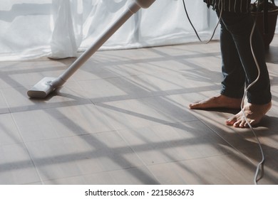 Person Cleaning Room, Cleaning Worker Is Using A Vacuum Cleaner To Clean The Living Room Floor In The Company Office. Cleaning Staff. Maintaining Cleanliness In The Organization.