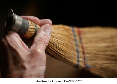 Person Cleaning With Small Whisk Broom