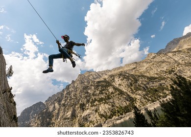 Person climbing in high mountains with yellow jacket rope and helmet in nature, confidence and risk, safety - Powered by Shutterstock