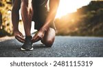 Person, closeup and tying shoes with hands in street for running, morning workout or outdoor exercise. Active athlete, runner or tie laces in preparation, getting ready or fitness for cardio on road