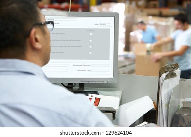 Person At Computer Terminal In Distribution Warehouse