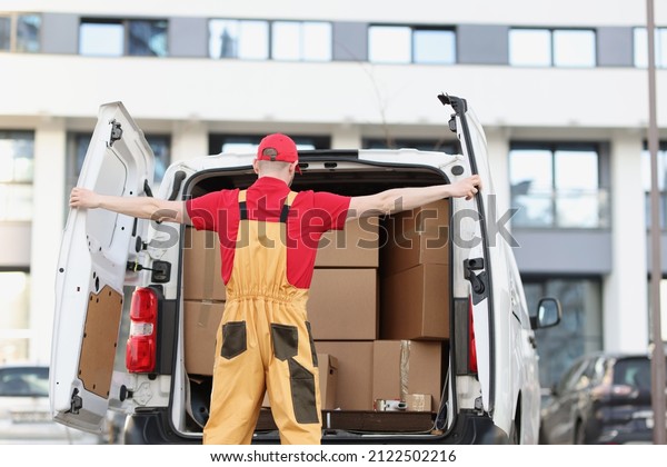 Person courier closing car door with both hands,\
view from back
