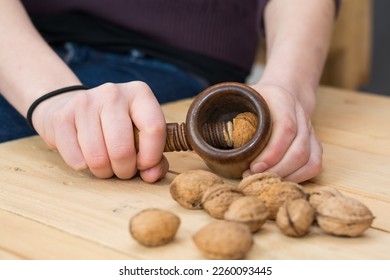 Person cracks on a wooden table walnuts with nostalgic Nutcracker