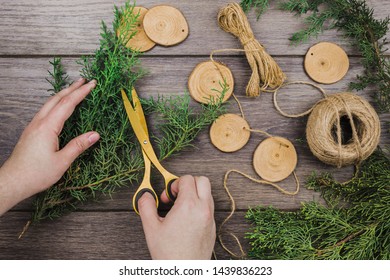 A person cutting the fir twig for making the handmade bunting on wooden desk - Powered by Shutterstock