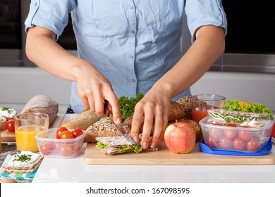 A Person Cutting A Sandwich While Making A Healthy Lunch