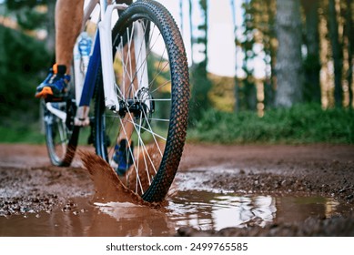 Person, cycling and mountain biking in nature with wheel, mud and splash for fitness, adventure and health. Cyclist, bicycle and exercise outdoor in forest for workout, sports and training with trees - Powered by Shutterstock