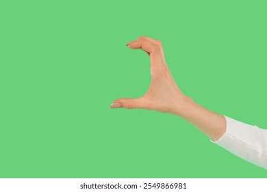 Person demonstrating a hand gesture against a solid green background for creative expression or design purposes - Powered by Shutterstock