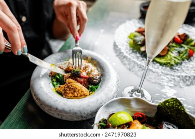 A person dining at a restaurant, enjoying a colorful gourmet dish served on a unique marble plate, capturing the fine dining experience - Powered by Shutterstock