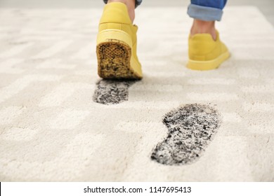 Person In Dirty Shoes Leaving Muddy Footprints On Carpet