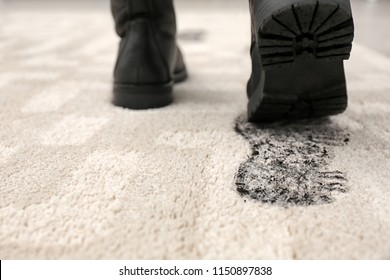 Person In Dirty Shoes Leaving Muddy Footprints On Carpet