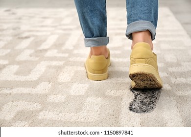 Person In Dirty Shoes Leaving Muddy Footprints On Carpet