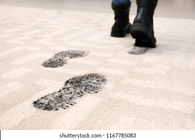 Person In Dirty Shoes Leaving Muddy Footprints On Carpet