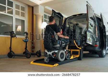 Person with disability accesses a van using a wheelchair lift in a parking area. The setting is urban and designed for inclusivity.