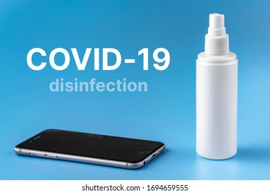 A Person Disinfects The Phone With An Antiseptic To Protect Themselves From Covid-19 Infection. The Concept Of Cleaning The Phone From Airborne Bacteria And Viruses