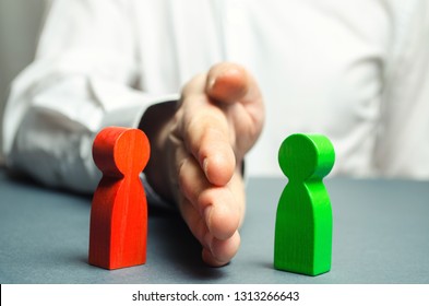 The person divides with the palm the red and green figures of people. Orbiter, the solution of controversial issues and conflicts of interest. Stop the conflict, the mediator. Dispute resolution. - Shutterstock ID 1313266643