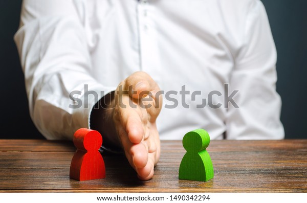 The person divides with the palm the red and\
green figures of people. Orbiter, the solution of controversial\
issues and conflicts of interest. Stop the conflict, the mediator.\
Dispute resolution.