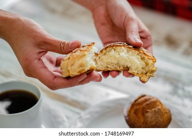 A person dividing a piece of bread into two parts - Shutterstock ID 1748169497