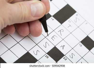 A Person Is Doing A Crossword Puzzle. It Is A Good Training For Brains Specially For Elderly People And Good For Stress Relieve. The Word Stress Is Written On The Crossword Puzzle.