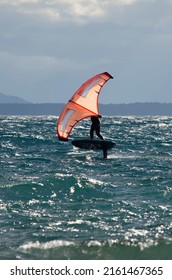 Person Doing Kitesurfing On A Lake With Mountains In The Background, Sailing Water Sport