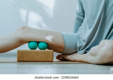 Person Doing Self Myofascial Release Of Hamstrings With Two Massage Balls On Cork Block.