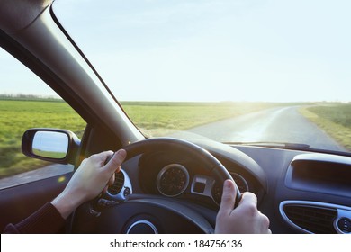 Person Driving Car With Blue Sky And Green Grass