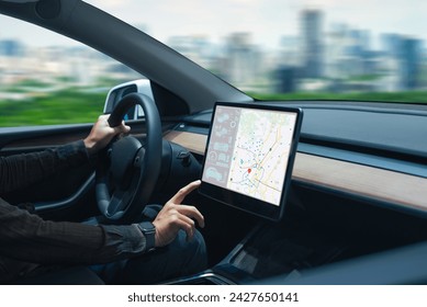 Person driving a car while interacting with a modern touchscreen navigation map in the dashboard.
 - Powered by Shutterstock