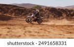 Person, driving and desert with motorbike for sport of speed training, performance technique and fitness journey. Athlete, driver and bicycle power for travel adventure, dirt cycling and race rally