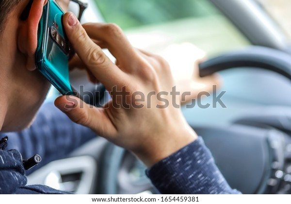 person driving with his\
phone in hand
