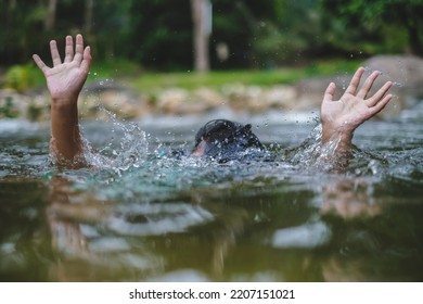 Person drowns in the river reaching for help. Hand drowning children sticking out of the water. Selective focus.