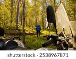 A person explores a lush green forest while parked Quad bike or ATV on a sunny day. Berry and mushroom picker