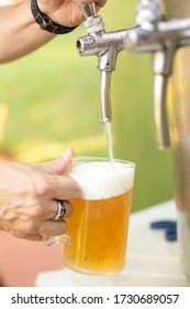 Person Filling A Glass Of Draft Beer In The Beer Cooler
