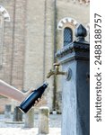 A person fills a thermos bottle at a nasone, a free public water fountain in Italy, on a hot summer day