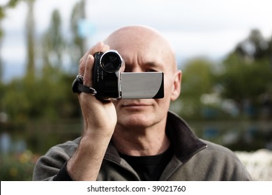 Person Filming A Scene With A Hand Held Camcorder