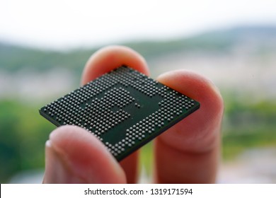 A person finger holding a Ball Grid Array Integrated Circuit or BGA IC. BGA IC is the finest technology for surface mount device