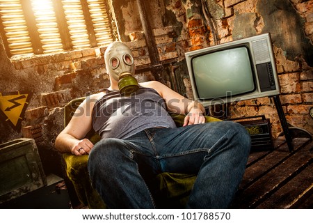 person in a gas mask sits on an armchair